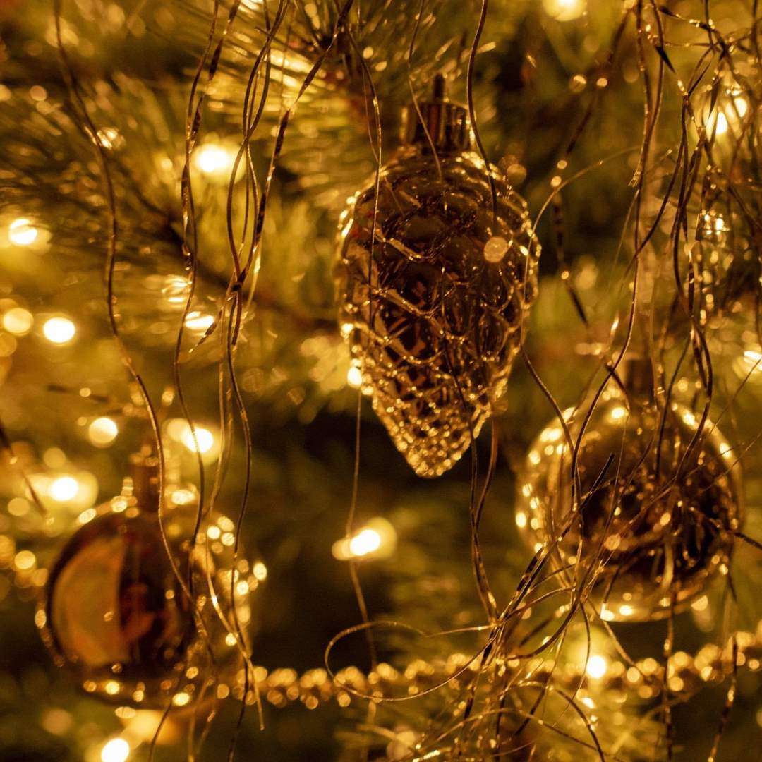 Nahaufnahme von bunten Weihnachtsbaumkugeln, die an einem geschmückten Weihnachtsbaum hängen