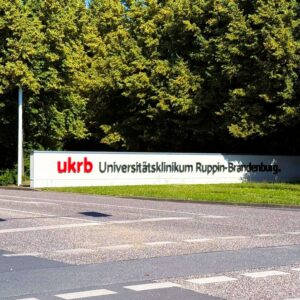 Eingangsmauer des Universitätsklinikums Ruppin-Brandenburg mit ukrb-Schriftzug.